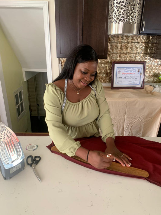 ModeBiBi designer measuring burgundy fabric during tailoring work